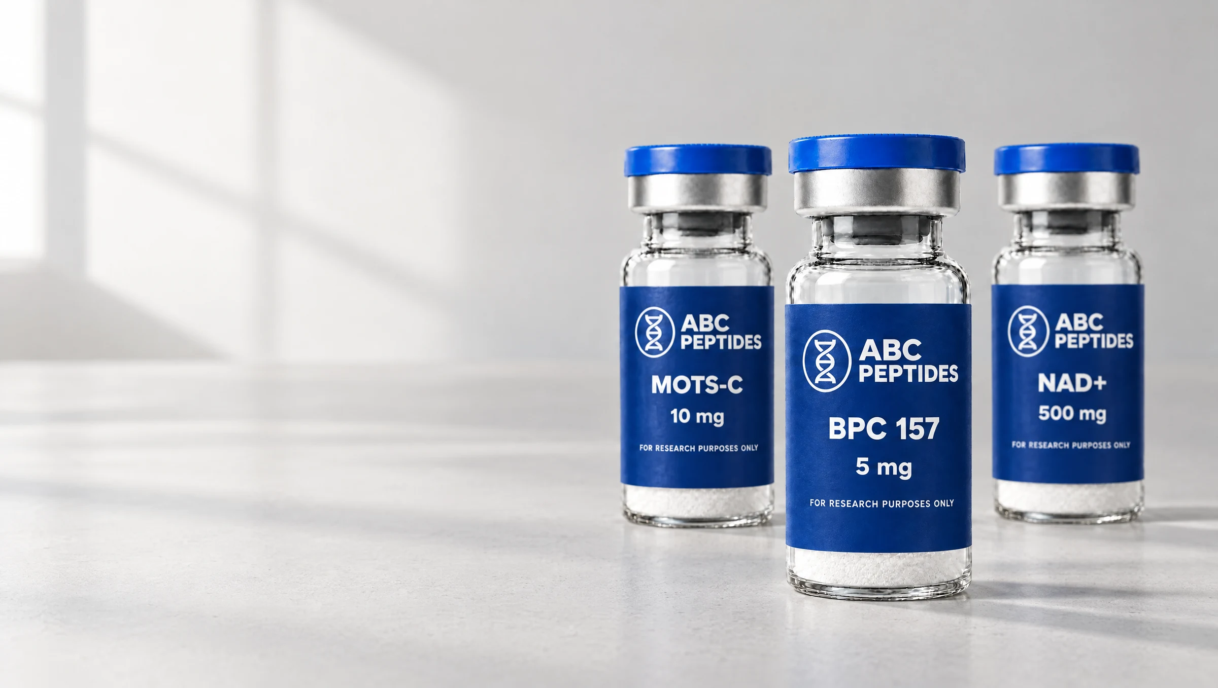 ABC Peptides BPC 157, MOTS-C and NAD+ vials photographed together in soft natural daylight